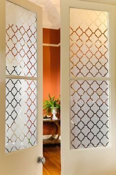 an open door with decorative glass panels on the front and back doors, in a home