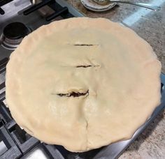 an uncooked pie sitting on top of a stove