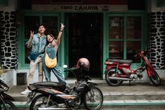 two people standing in front of a building with motorcycles