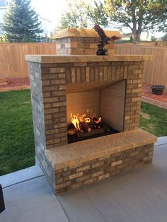 an outdoor fireplace with fire in it