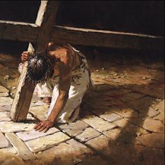 a person kneeling down on the ground with a cross in front of them and an image of jesus