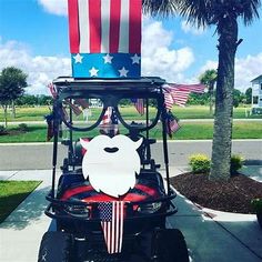 a golf cart decorated with an american flag and a white face on the front windshield