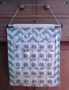 a blue and white calendar hanging from a wooden wall with clothes pins on the pegs