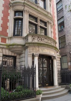 an ornate building with wrought iron gates and stairs