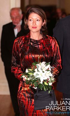 a woman in a red dress holding a bouquet of flowers