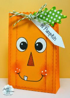 an orange paper bag with a green bow on it's head that says happy thanksgiving