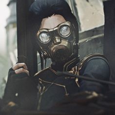 a man in a gas mask holding a cell phone