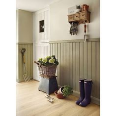 a basket filled with flowers sitting on top of a wooden floor next to gardening utensils