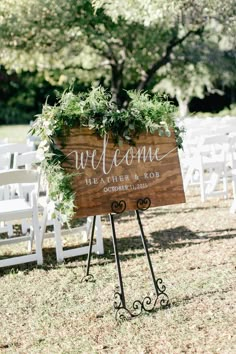 a welcome sign sitting on top of a metal stand in front of white folding chairs