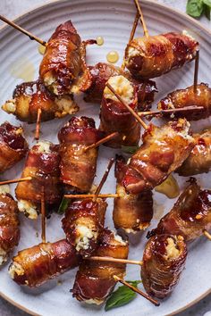 bacon wrapped skewers on a plate with toothpicks