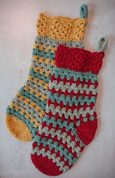 two crocheted christmas stockings hanging on the wall