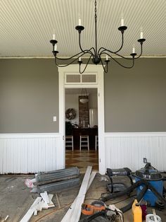 a chandelier hanging from the ceiling in front of a doorway that is being remodeled