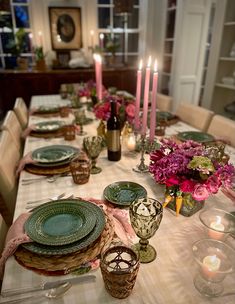 the table is set with plates and candles