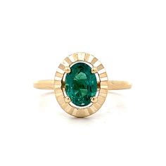 an oval shaped green tourmaline stone in a yellow gold ring with diamond accents