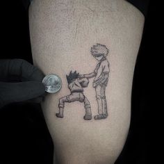 a person with a small tattoo on their leg is touching another person's knee