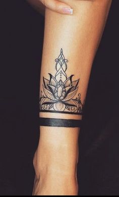 a woman's arm with a tattoo on it and a wristband in the shape of a lotus