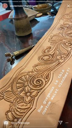 a close up of a wooden carving on a table with a pen and inkwell