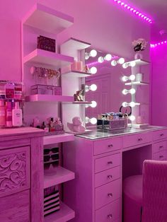 a pink vanity with lighted lights in a room