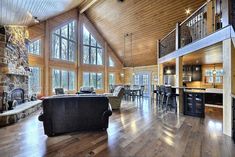 a living room filled with furniture and a fire place in front of a stone fireplace