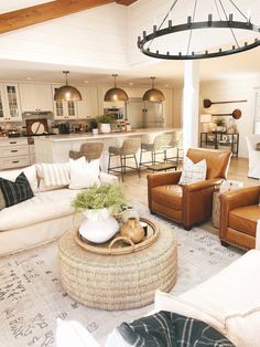 a living room filled with furniture next to a kitchen