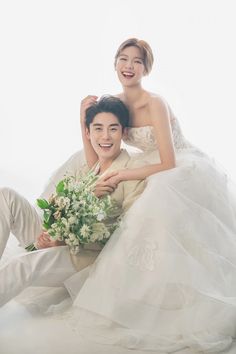 the bride and groom are posing for their wedding photo shoot in front of a white background