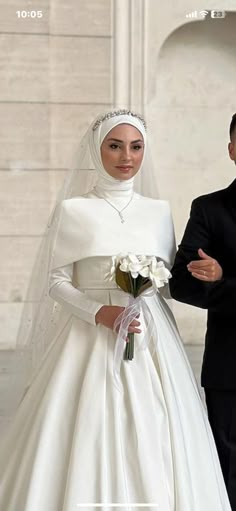 a man and woman in wedding attire standing next to each other