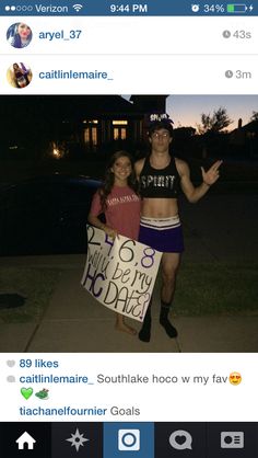 two people standing on the sidewalk holding signs