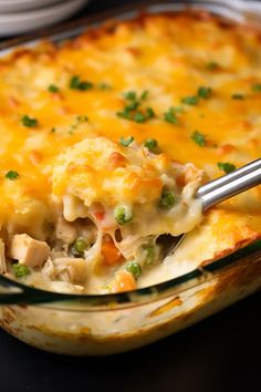 a casserole dish with chicken and vegetables in it is being held by a fork