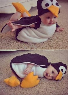 a baby in a penguin costume laying on the floor