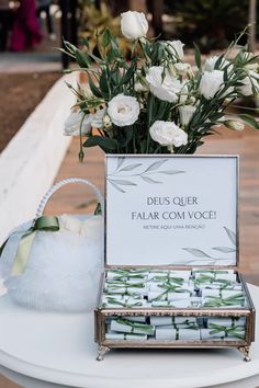 a table topped with a box filled with white flowers