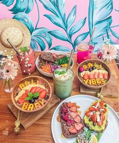 a wooden table topped with plates and bowls filled with different types of food on top of it