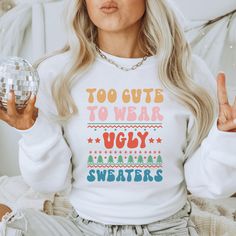 a woman in a white sweater holding a disco ball and making the peace sign with her hands