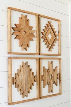 three wooden wall art pieces hanging on the wall in front of a white painted wall