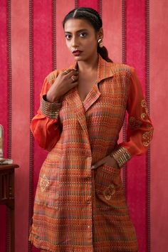 Rust orange blazer top with floral embroidery on the sleeves and back waist tie-up. Paired with a pant. - Aza Fashions Traditional Workwear Sets For Fall, Silk Long Sleeve Sets For Fall, Fall Silk Sets With Long Sleeves, Silk Sets For Workwear In Fall, Fall Silk Sets For Workwear, Orange Long Sleeve Party Sets, Workwear Sets With Embroidered Long Sleeves, Orange Long Sleeve Tops For Festive Season, Festive Orange Long Sleeve Blouse