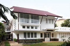 a large white house with lots of windows on it's sides and grass in front