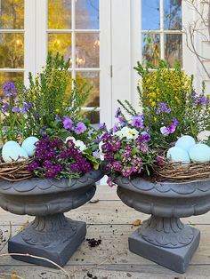 two bird's nest planters with flowers and eggs in them on a porch