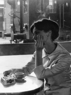 a woman sitting at a table with her hands to her face