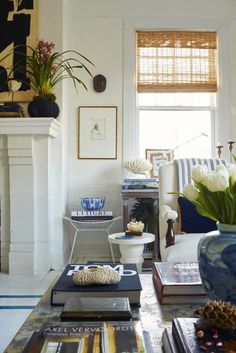 a living room filled with furniture and a fire place next to a white fireplace covered in pictures