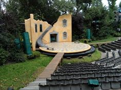 an outdoor stage with steps leading up to it and lots of seats in the foreground