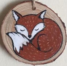 a wooden ornament with an image of a fox sleeping on it's side