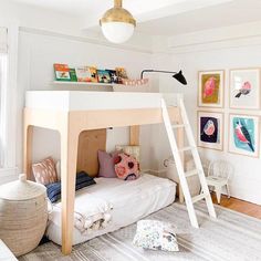 there is a bunk bed with a ladder on the bottom and pictures on the wall