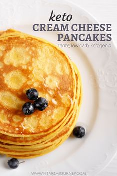 a stack of pancakes with blueberries on top and the words keto cream cheese pancakes above it