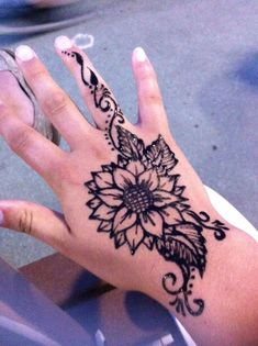 a woman's hand with a flower tattoo on it