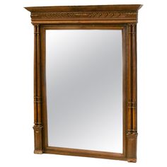 a large wooden mirror with an ornate frame on the top and bottom half of it