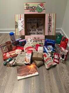 a pile of food sitting on top of a wooden floor next to a box filled with candy