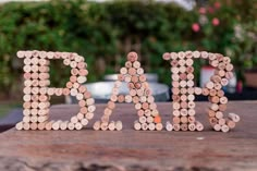 a word made out of wine corks sitting on top of a wooden table