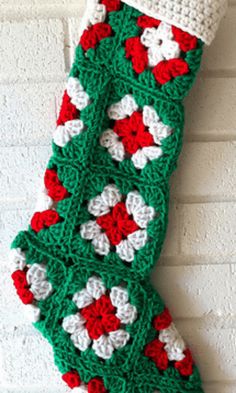 a crocheted christmas stocking hanging on a brick wall