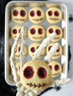 a cookie decorated like a skeleton with red eyes and bones in front of some cookies