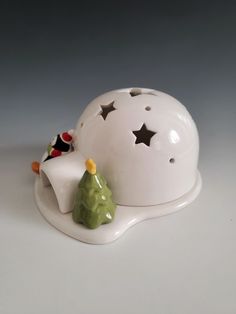 a white ceramic object with a christmas tree on top