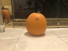 a pumpkin sitting on the floor in front of a mirror with its face drawn out